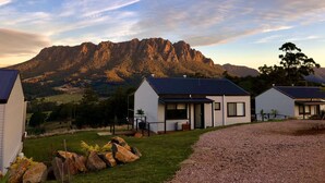A modern house with a large mountain in the background.