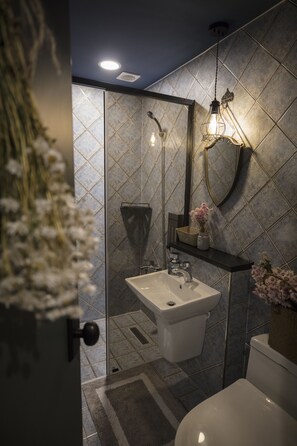 A modern bathroom with a white sink, a toilet, and a shower area. - SS Resort (Gapyeong)