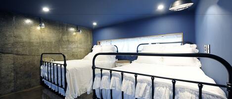 A bedroom with a metal bed frame, white bedding, and a headboard.