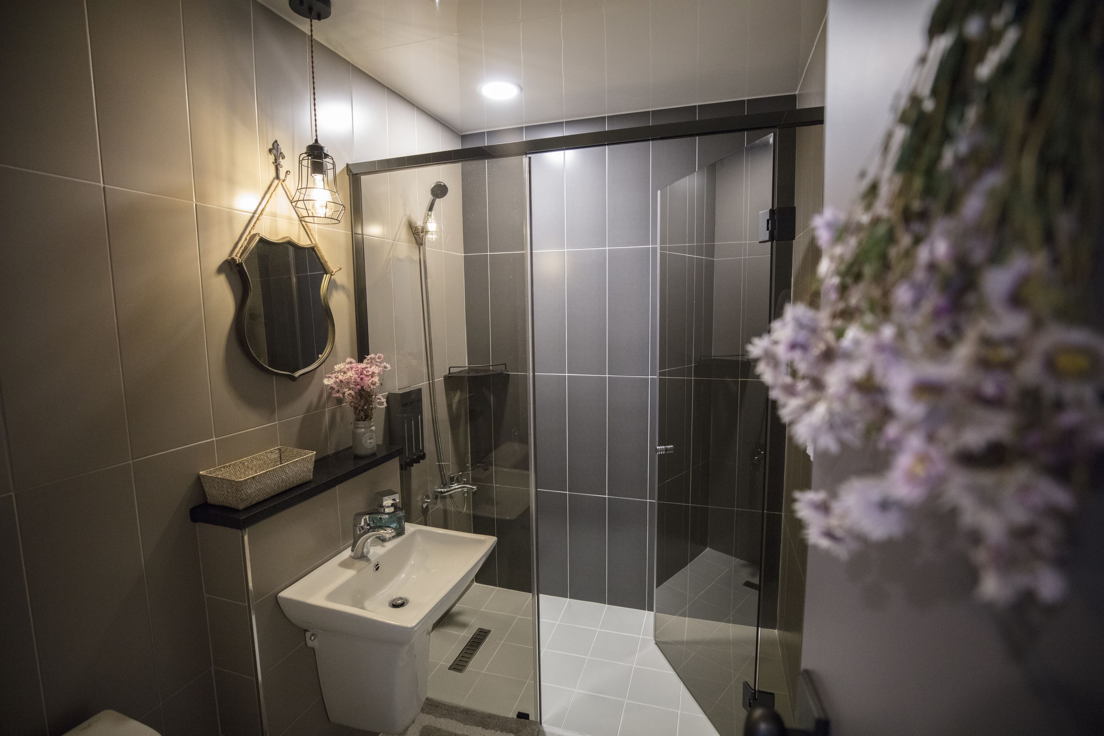 A modern bathroom with a glass-enclosed shower, a sink, and a mirror.