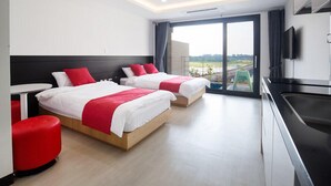 A modern hotel room with two beds, a dining table, and a kitchen area. - Christmas Resort (Jeju City)