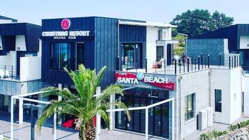 Un edificio moderno con un letrero que dice 'Christmas Resort' y 'Santa Beach Coffee & Bakery'.