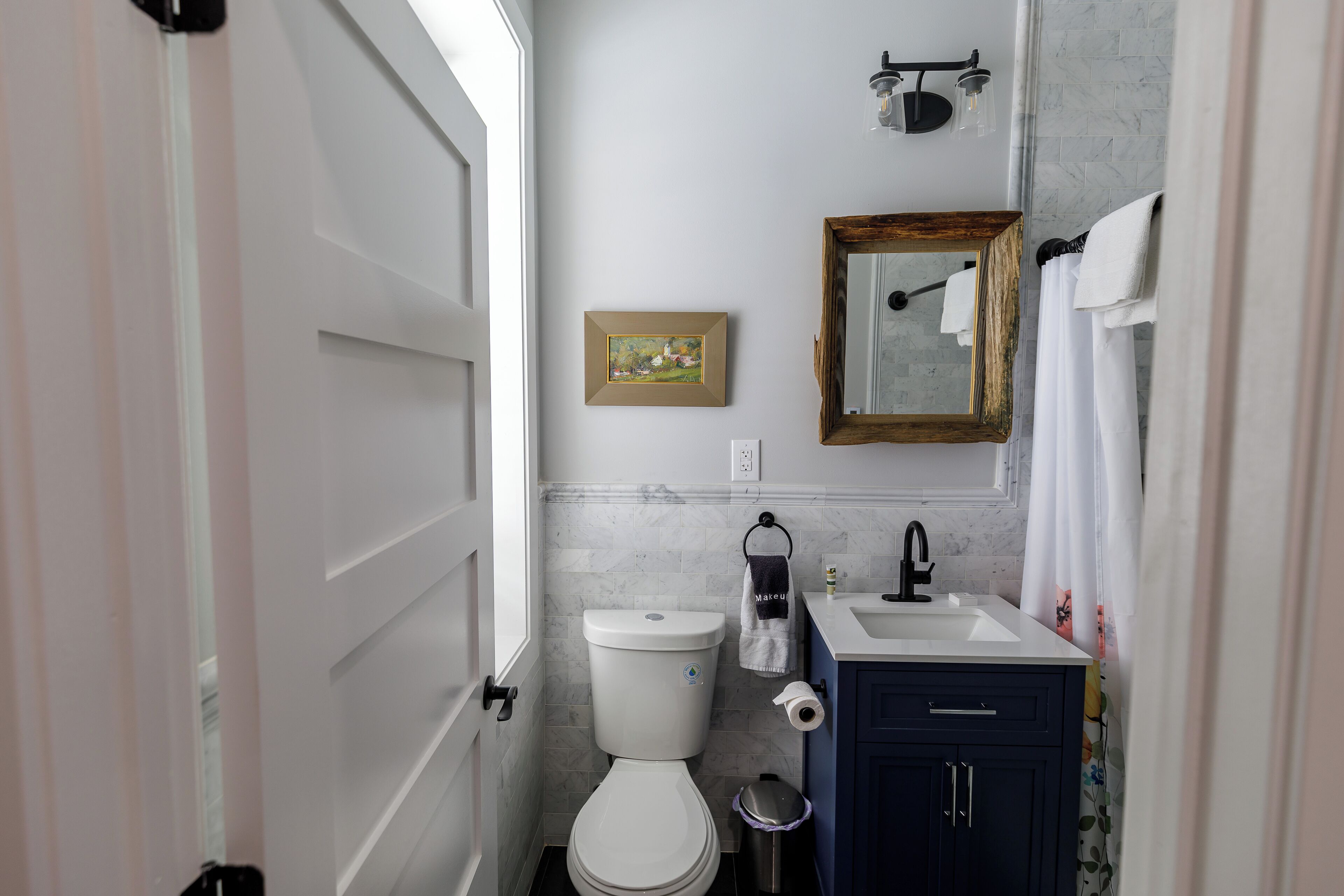 A bathroom with a toilet, sink, and mirror.