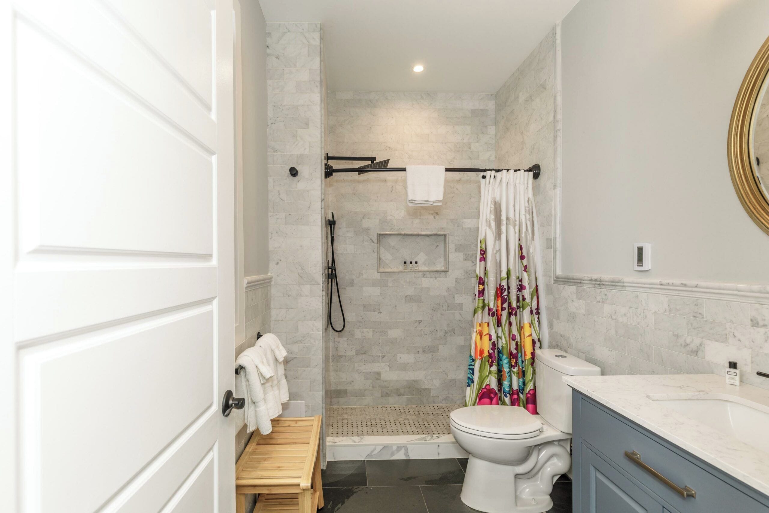 A modern bathroom with a shower, toilet, and vanity.