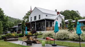 A white building with a porch and outdoor seating area. - The Inn At Warm Springs (Warm Springs)
