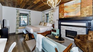 A cozy bedroom with a large bed, a fireplace, and a rustic ceiling. - The Inn At Warm Springs (Warm Springs)