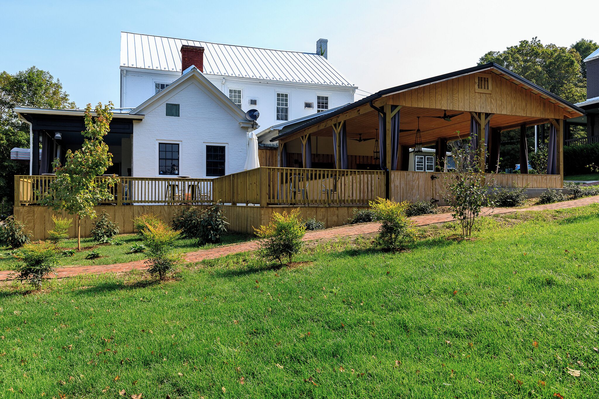 A two-story house with a covered porch and a small garden.