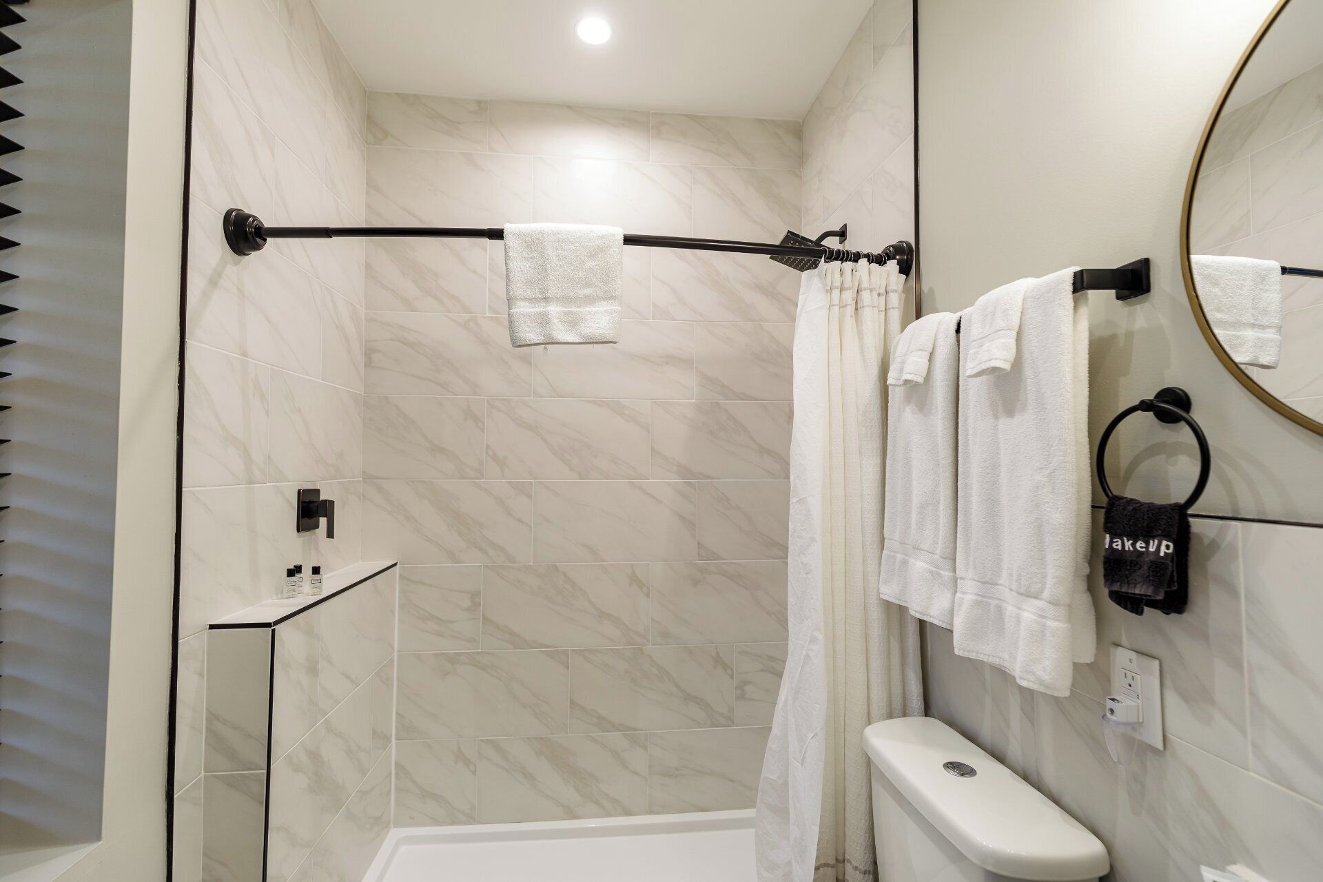 A modern bathroom with a shower, toilet, and sink.