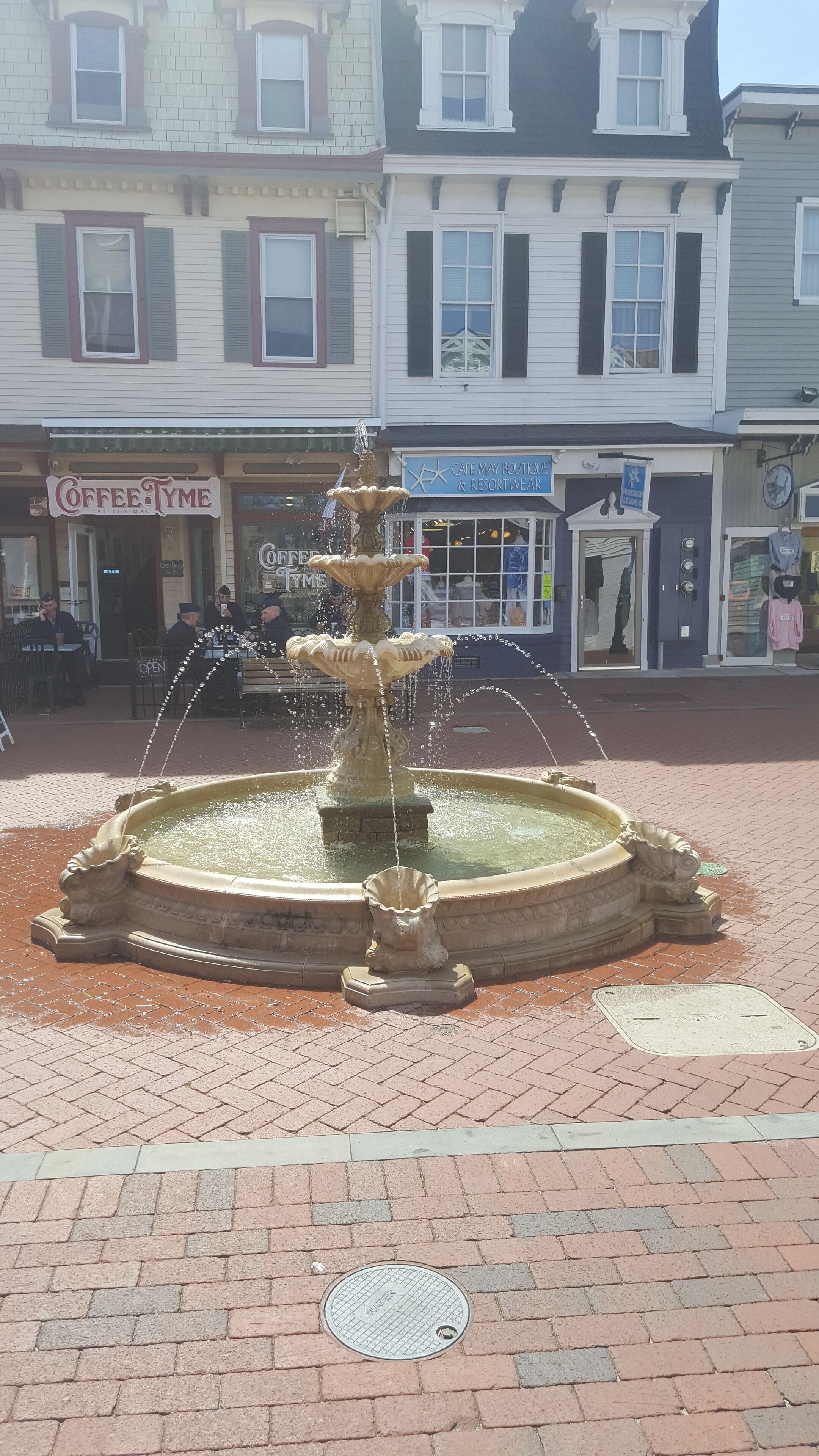 Una fuente pública en una plaza con pavimento de ladrillo.
