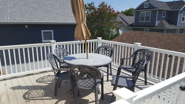 A deck with a round table and four chairs, surrounded by a white railing. - Great Location In Cape May, NJ. Just 4 Blocks To Beach And Washington St Mall (Cape May)