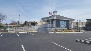 A building with a blue and white facade, a flag, and a sign that reads "Cape May's Finest". - Great Location In Cape May, NJ. Just 4 Blocks To Beach And Washington St Mall (Cape May)