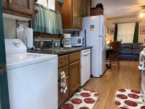 Una cocina compacta con lavadora, microondas y refrigerador.