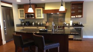 Una cocina moderna con una isla central, electrodomésticos de acero inoxidable y un horno empotrado.
