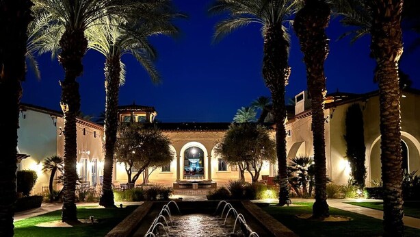 A courtyard with a water feature, palm trees, and a building with arched windows and a fountain. - La Villa #1 * Townhouse * 12 Pools *WoW Views (La Quinta)