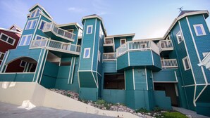 A multi-story building with a unique architectural design, featuring balconies and a steeply pitched roof.
