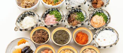 Diverse soorten eten, zoals vlees, groenten en sauzen, gepresenteerd in kommen en op borden.