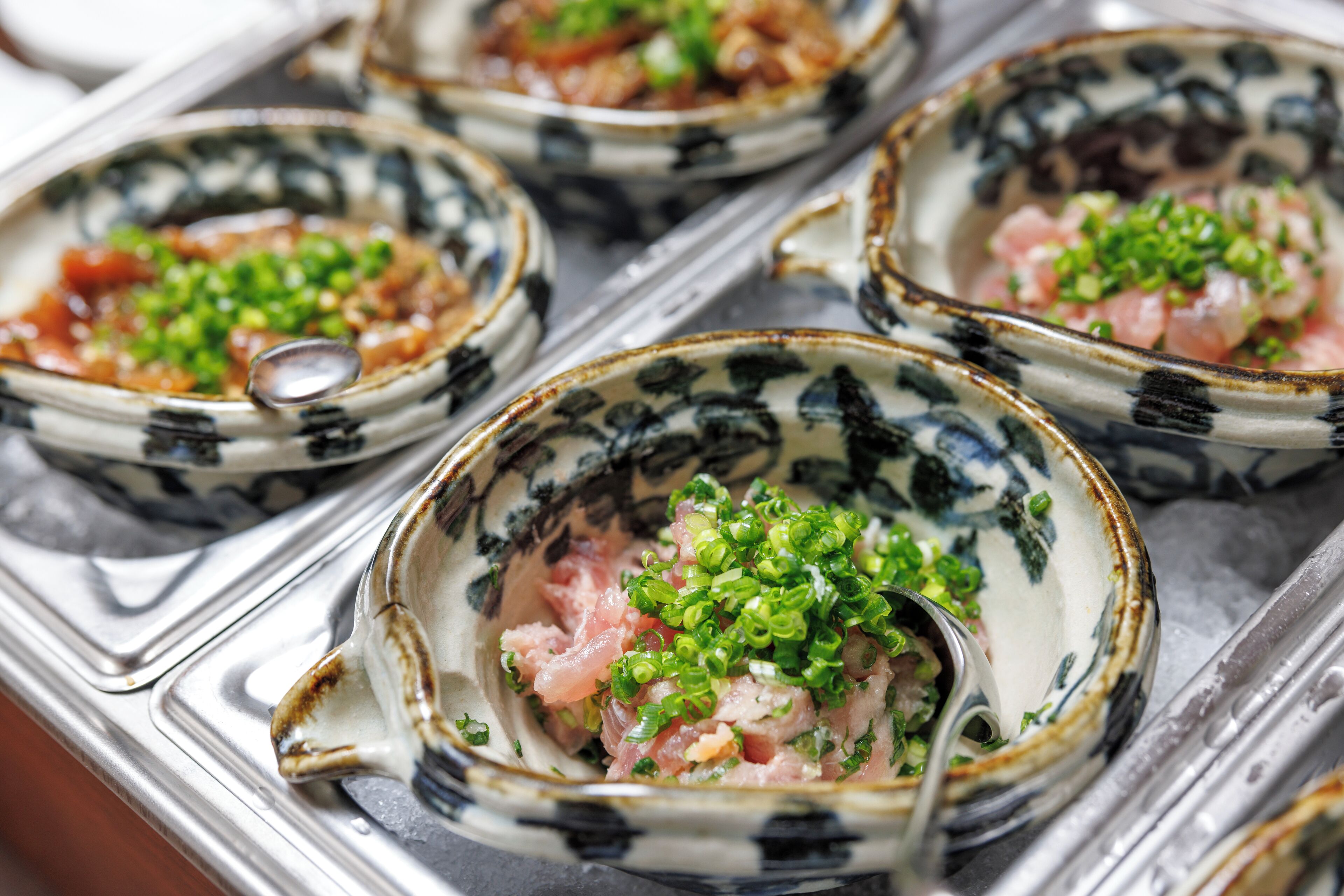 A tray of seafood dishes in decorative bowls.