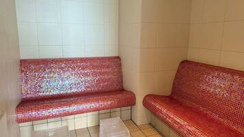 A room with two red mosaic benches and a small table.