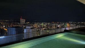 Una terraza en la azotea con vistas a la ciudad de noche.