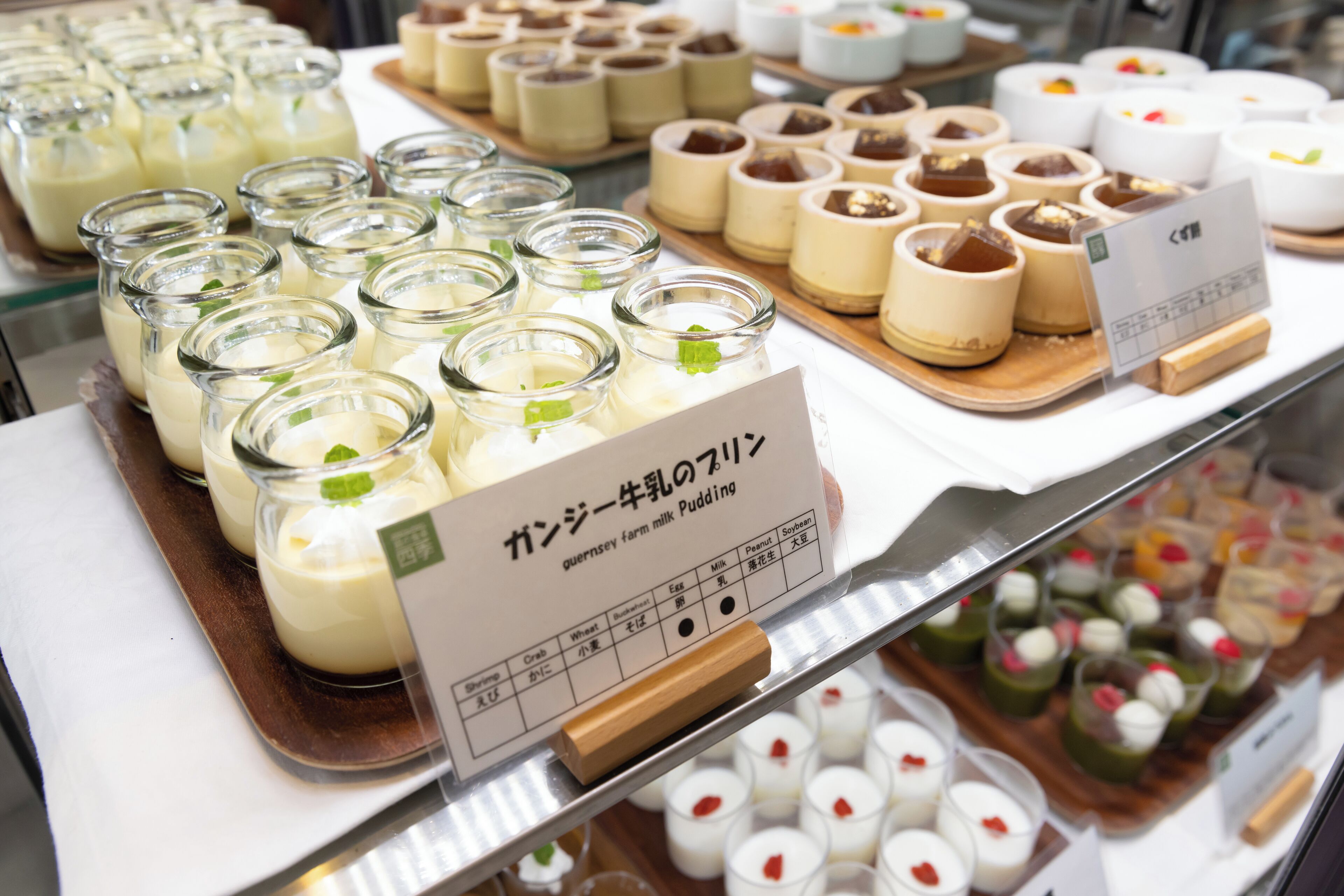 Une variété de desserts, notamment des crèmes et des puddings, présentés sur des plateaux.