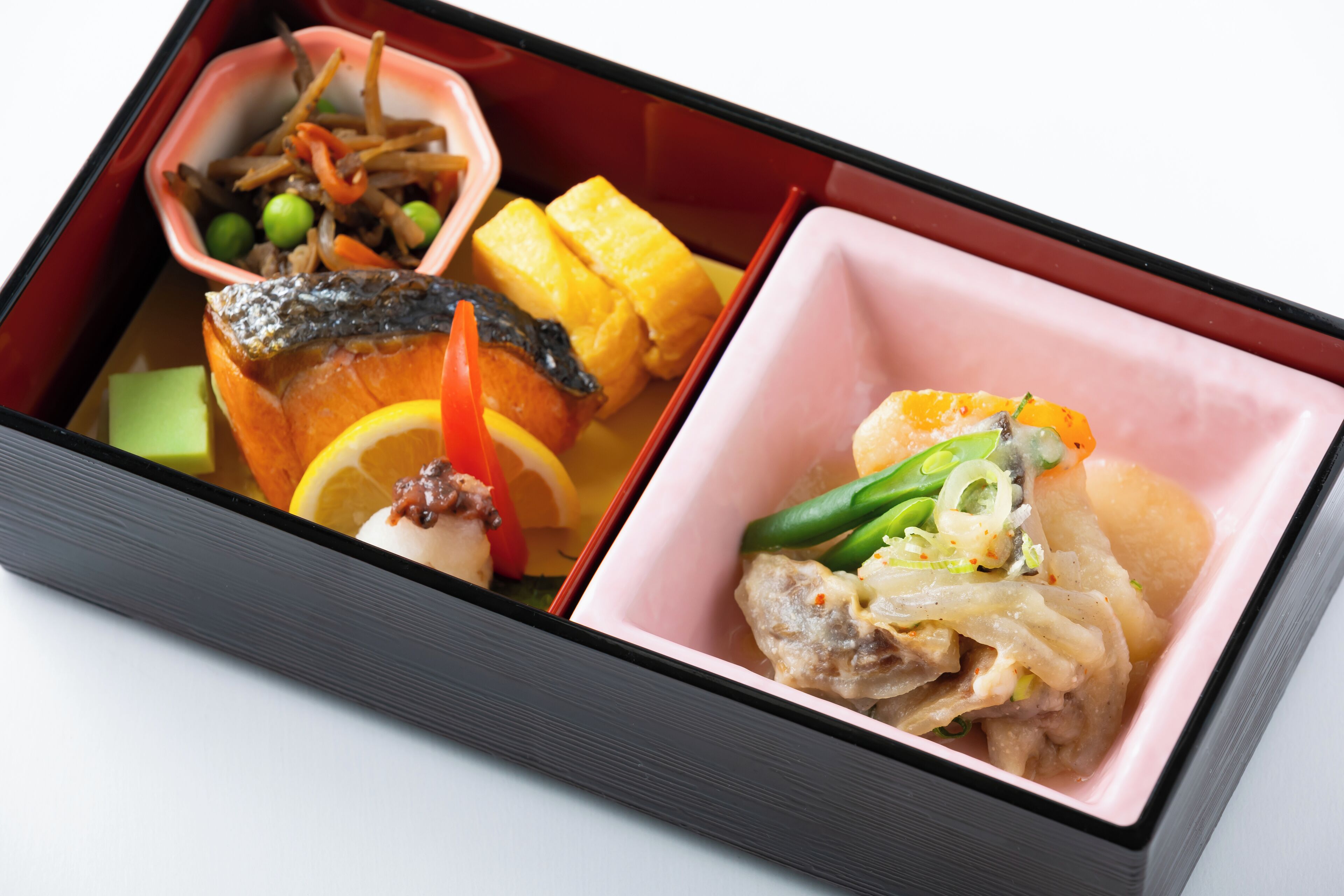 A bento box with various food items including fish, vegetables, and tofu.