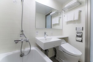 Un baño moderno con bañera, lavamanos e inodoro.