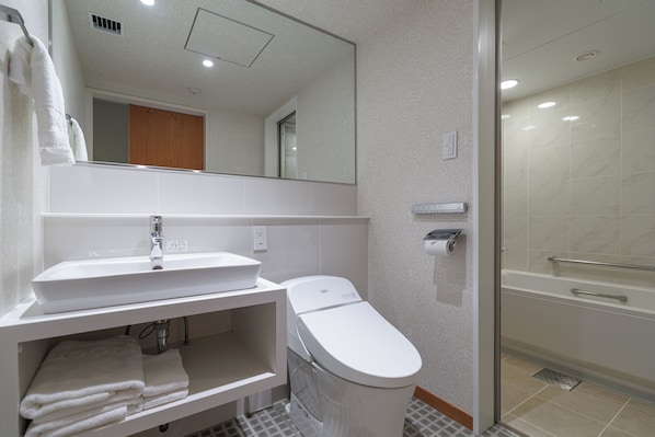 Une salle de bain moderne avec un lavabo blanc, des toilettes et une douche à parois de verre.