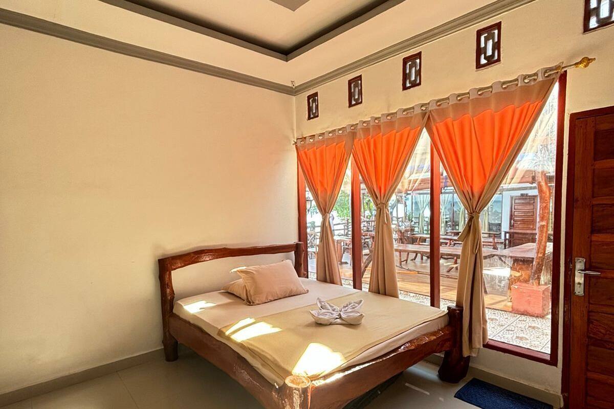 Un dormitorio con una cama de madera, vista al exterior y una puerta.