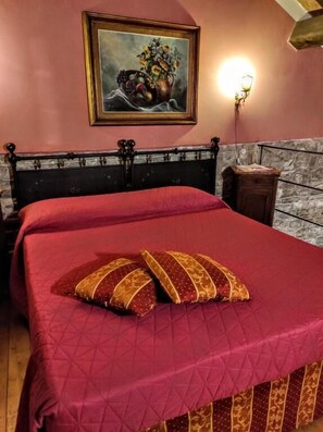 A room with a bed, a painting on the wall, and a nightstand. - B&B Eremo Gioioso (Pontremoli)