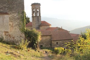 A rustic stone building with a bell tower, surrounded by greenery and a clear path. - B&B Eremo Gioioso (Pontremoli)
