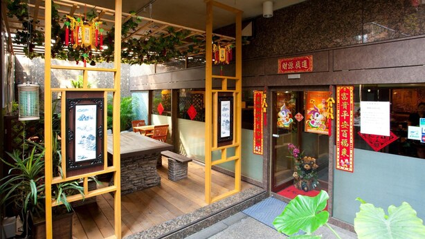 A traditional Chinese restaurant with wooden lattice structures, indoor plants, and red decorations. - Pearlhotel Kawasaki (Kawasaki)