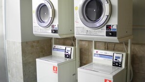 A laundry facility with two washing machines and two dryers, each marked with a number. - Pearlhotel Kawasaki (Kawasaki)