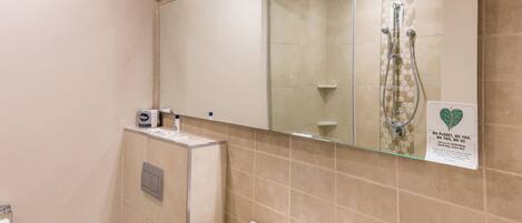 Une salle de bain avec des toilettes, un lavabo et une douche.