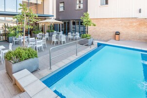 Una piscina al aire libre, tumbonas