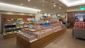 Uma loja bem iluminada, com diversos produtos expostos em prateleiras e balcões, incluindo embalagens e caixas.