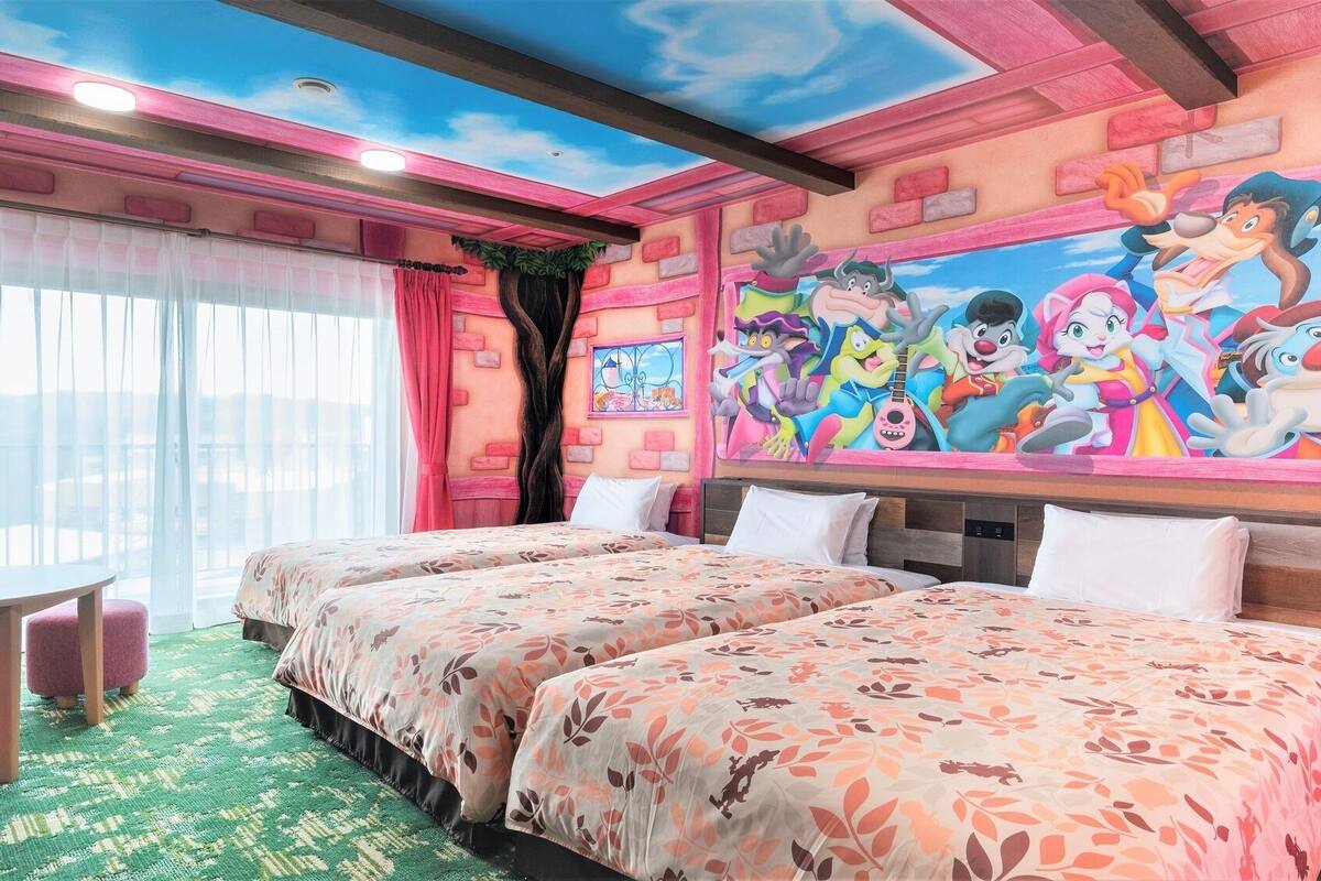 Een hotelkamer met twee bedden, een groot muurschildering en uitzicht op de omgeving.