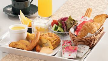 A tray with breakfast items including toast, eggs, a salad, and juice.