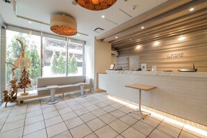 A reception area with a white reception desk, a bench, and a wall-mounted sign that reads 'ILFLORE'. - Hotel IL FIORE Kasai (Tokyo)