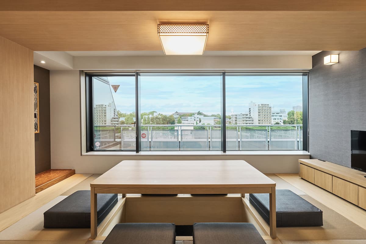A modern room with a large window, a wooden table, and a built-in TV.