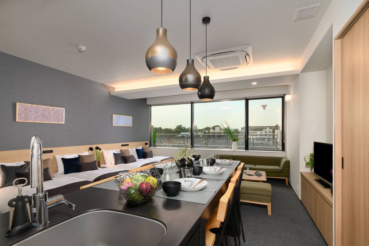 A modern kitchen with a large island, built-in appliances, and a dining area with a view of the city.