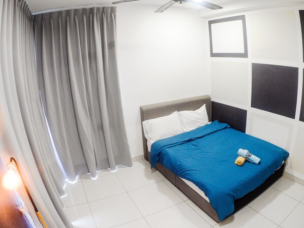 A bedroom with a bed, curtains, a ceiling fan, and a wall with geometric patterns.