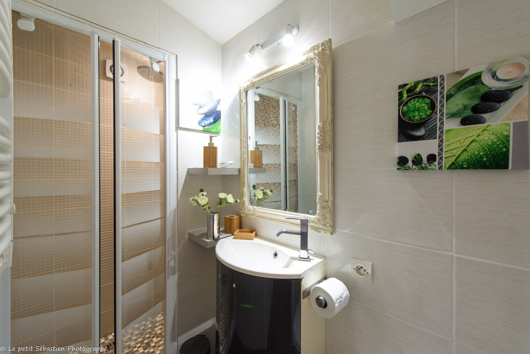 A bathroom with a glass shower enclosure, a sink with a mirror, and a toilet.
