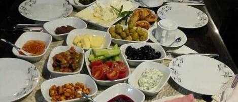 A table set with various dishes, including bread, fruits, and a variety of spreads.