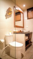 Un baño con inodoro, lavabo y espejo.
