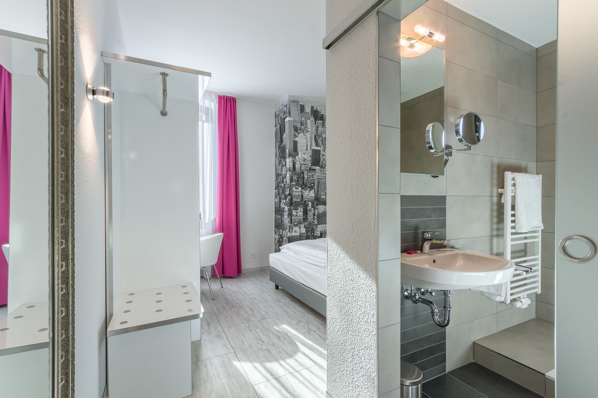 A modern bathroom with a shower, a sink, and a mirror.