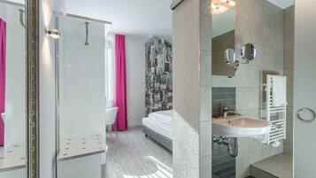 A modern bathroom with a shower, a sink, and a mirror.