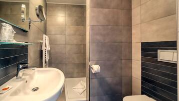 A modern bathroom with a sink, mirror, and toilet.
