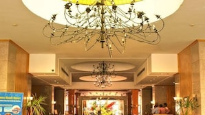 A hotel lobby with a checkered floor, a chandelier, potted plants, and a reception desk. - Kefi Palmera Beach Resort El Sokhna - Family Only (Ataqah)