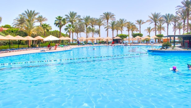 A large swimming pool with multiple lanes, surrounded by palm trees and sun loungers. - Kefi Palmera Beach Resort El Sokhna - Family Only (Ataqah)