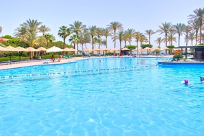 A large swimming pool with multiple lanes, surrounded by palm trees and sun loungers. - Kefi Palmera Beach Resort El Sokhna - Family Only (Ataqah)